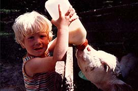 Child Seth Alberty feeding calf a bottle of milk at his grandparents farm
