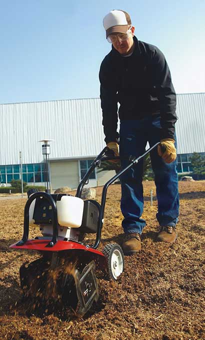Seth Alberty operating a garden cultivator outside of QianJiang factory in Wenling, China