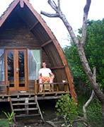 Seth Alberty sitting on front porch of his traditional bungalow hut in Gili Island, Lombok, Indonesia